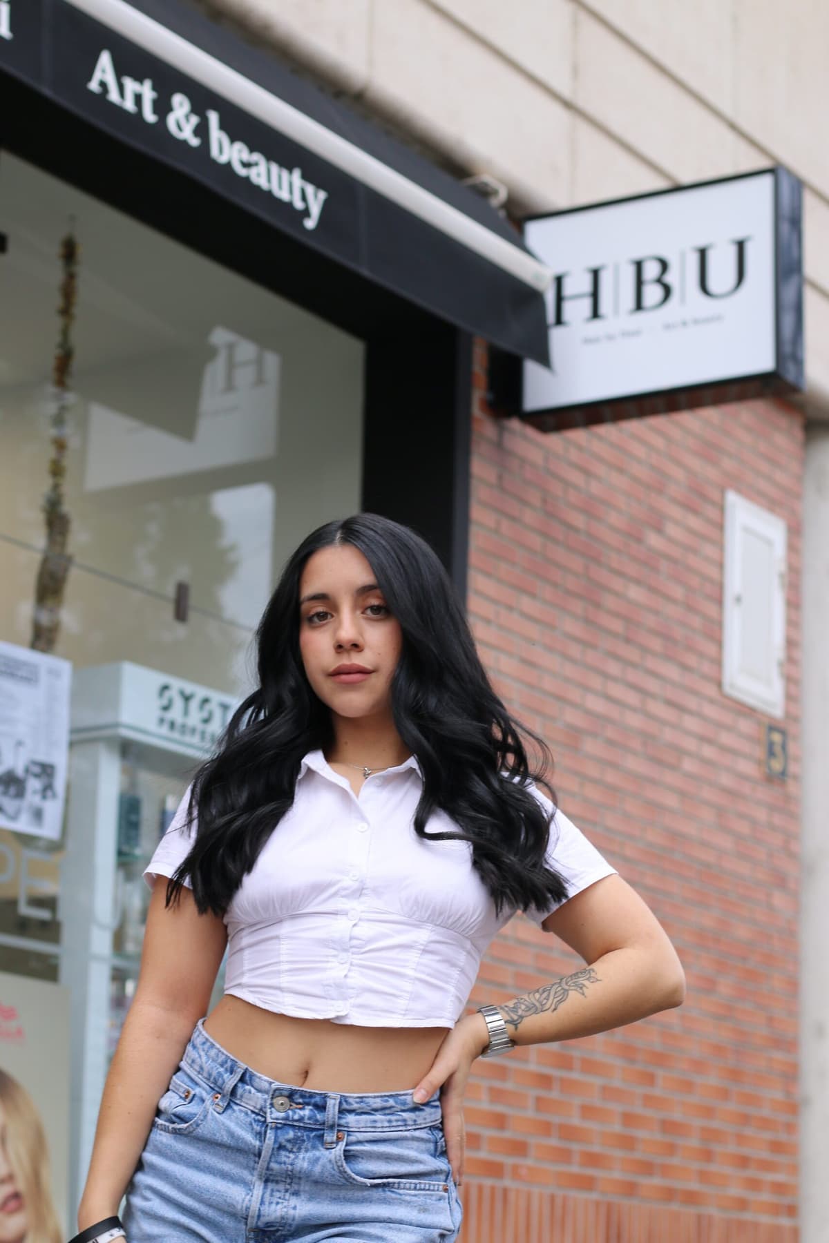 Clienta con melena larga en la fachada de Peluquería HBU, Vitoria-Gasteiz