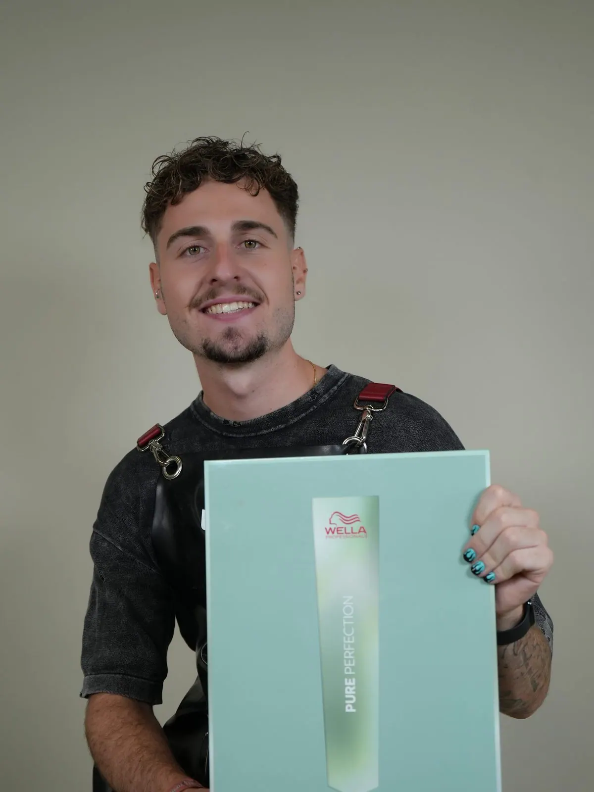 Unai, fundador de Peluquería HBU, sonriendo con producto Wella Professionals